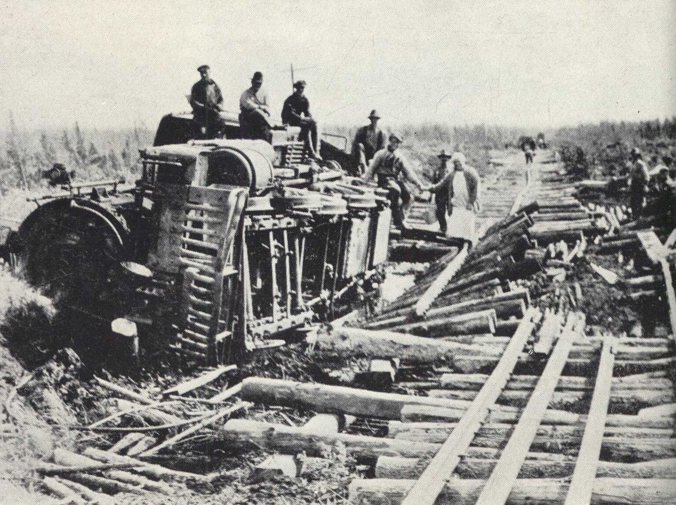 Group of men sitting on top of wrecked train engine