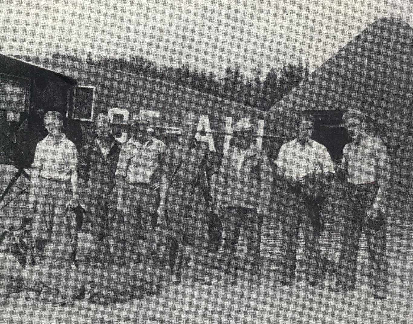 Group of men standing on dock in front of seaplane