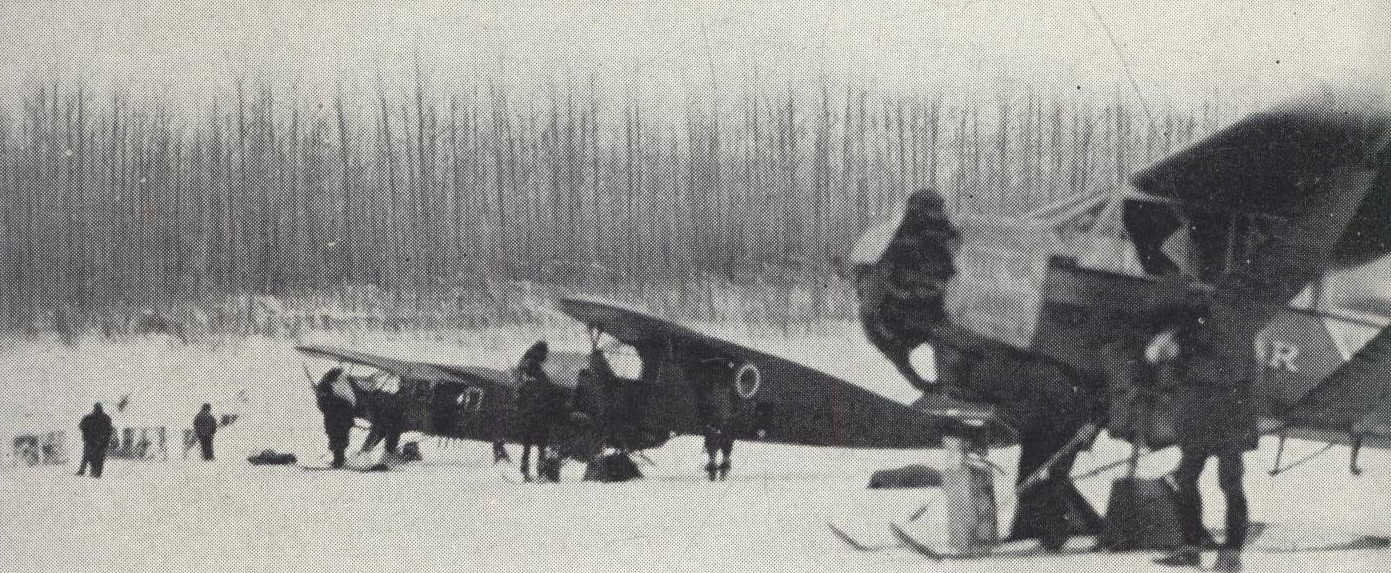 Three planes being unloaded on ice covered lake