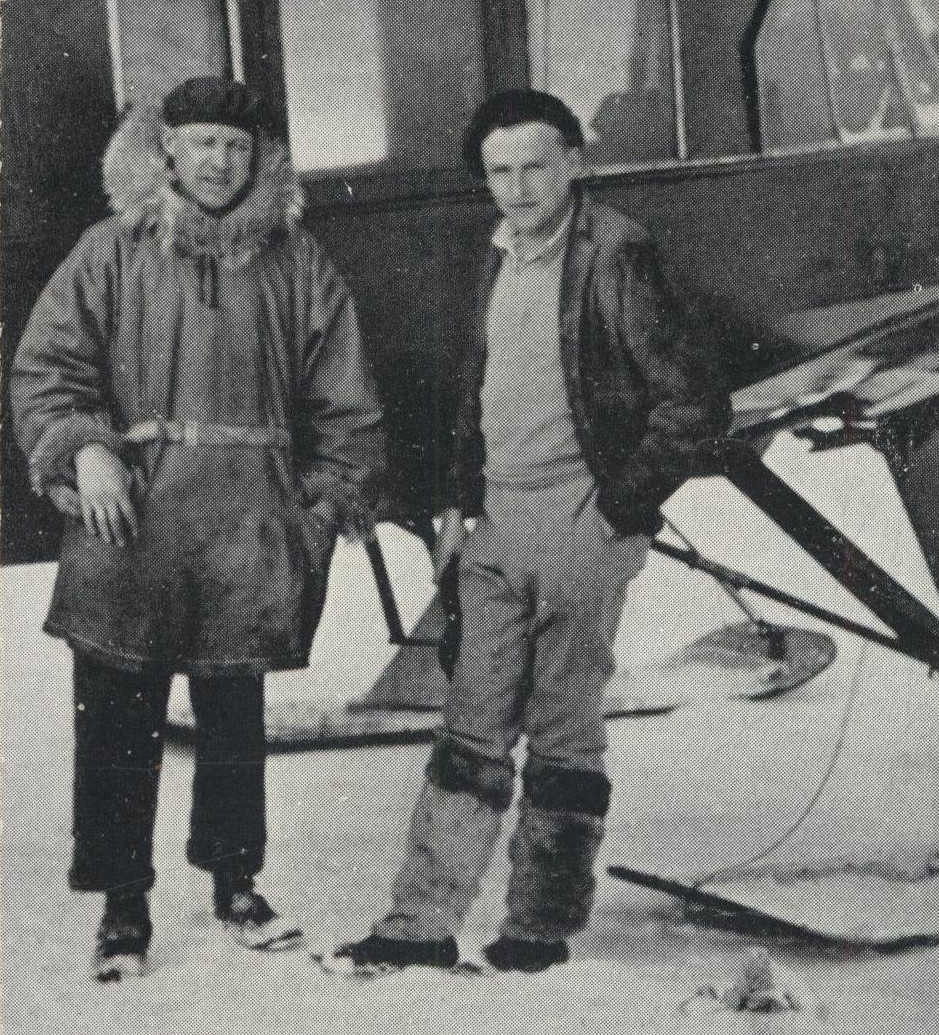 Two pilots stand before plane on skis