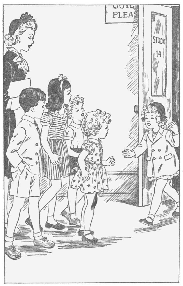 A girl wearing a hat and coat is walking up to another group of children with one adult in the group