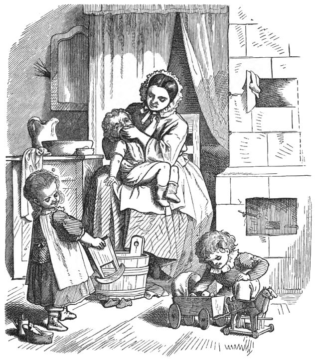 A woman is sitting on a chair holding a child while two other children are playing on the floor in front of her.