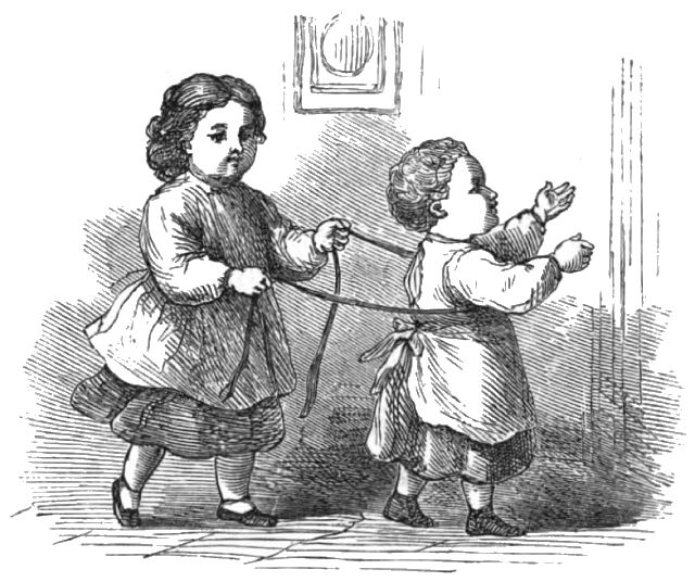A child has a rope around the waist of a second child as they play.