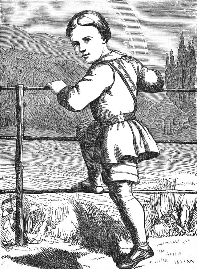 An outdoor scene as a boy stands at a fence with one leg on the fence