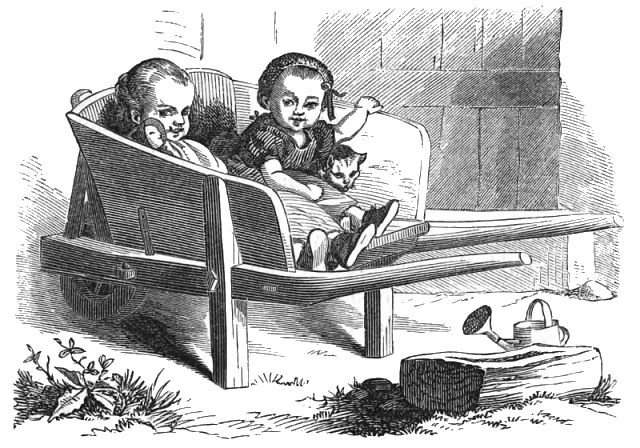 Two small children are sitting in a wheelbarrow with a cat and a doll
