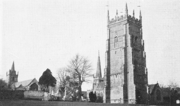 three-story bell tower with abbey buildings in background