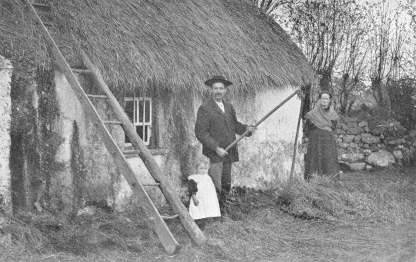 man standing before a cottage and holding a flail