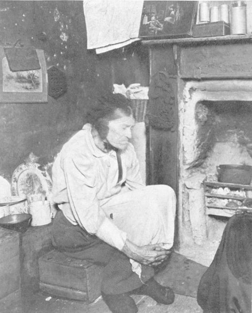 an old woman sitting by the fireplace