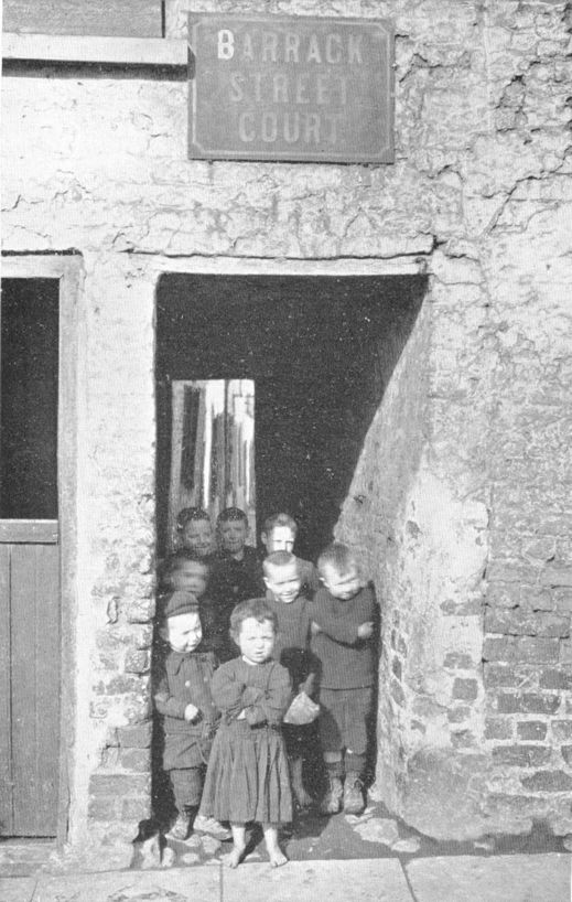 several children in a stone-walled passageway