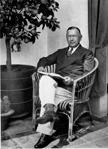 author seated in a chair with a book