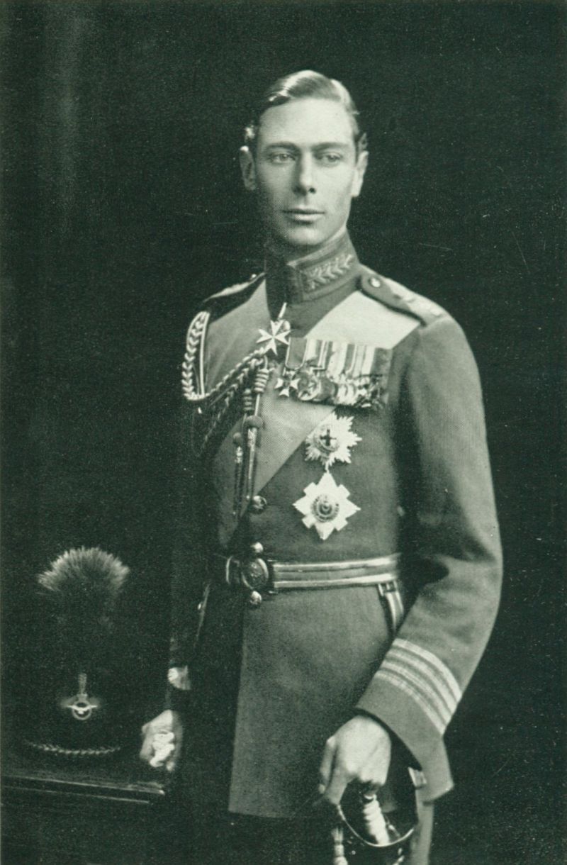 A man standing and wearing the complete military uniform of the time period.