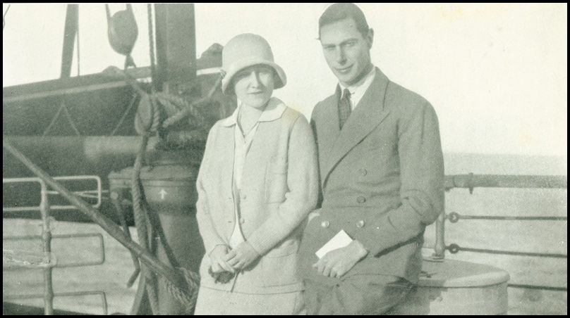 A man and woman are standing next to the railing on the deck of a ship.
