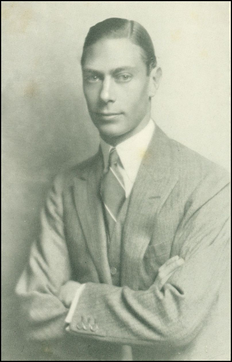 A close up photo of the king, wearing a suit and tie, and looking directly at the camera.