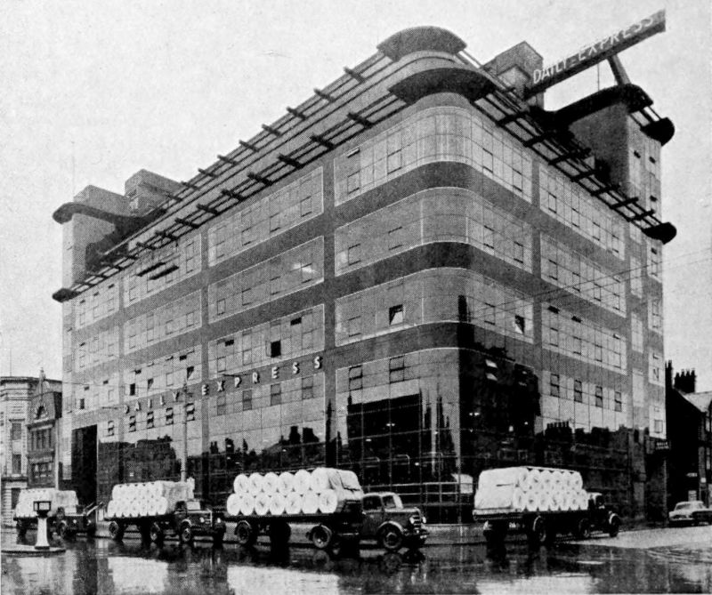 The photo shows a multi-storied building with Daily Express on the front of it. There are four trucks carrying what appears to be rolls of paper on the street in front of the building.