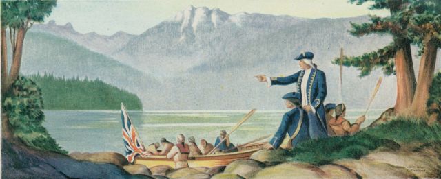 This is an outdoor scene taking place at the edge of a lake with towering mountains in the background. A man in a blue uniform is standing and pointing into the distance while another man in uniform is seated next to him. In the water is a boat with a British flag at the aft and multiple people seated in the boat. There are also two men seated behind the men in uniform each holding up an oar.