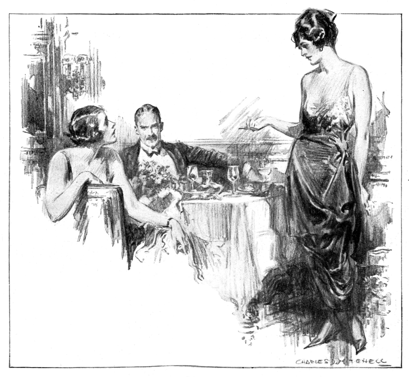 A woman and man seated at a formal dinner table with woman speaking to another woman standing in formal attire.