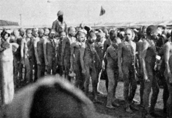 a line of naked men, all with painted bodies