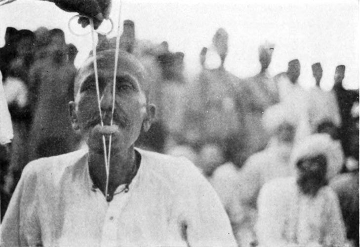 man with long skewers piercing his tongue