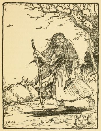 old Indian woman wearing a shawl and walking on a trail with a walking stick
