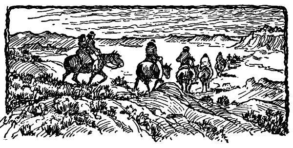 Indian boy and girl on a horse bringing up the rear of a line of horse riding through the desert