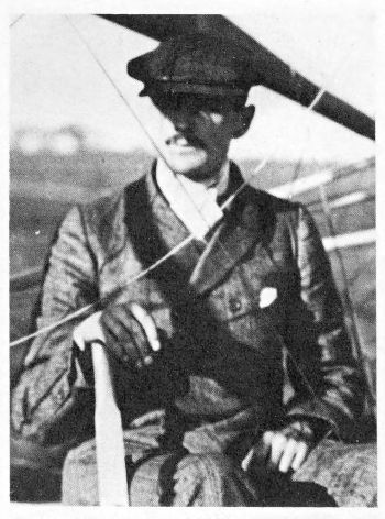moustached man wearing cap under plane wing