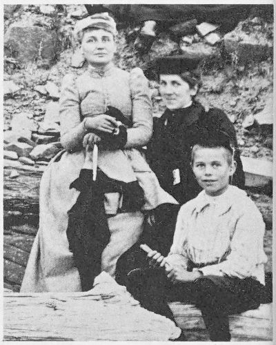 2 ladies and a boy seated on rocks