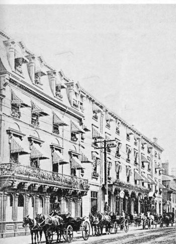 4 story building with horse-drawn carriages in front