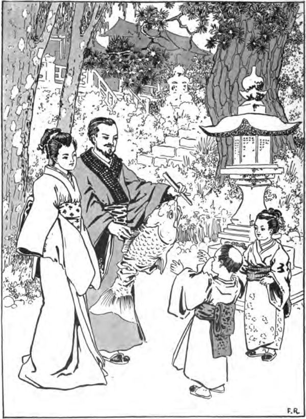 a Japanese family playing with a fish-shaped kite