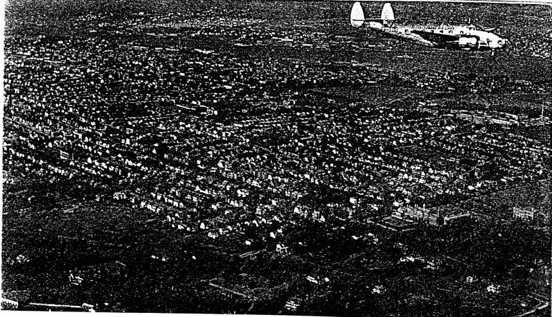 Plane in flight over a city