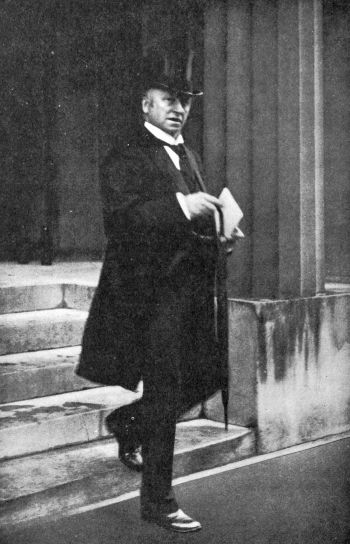 man in formal attire and tophat and cane leaving a building