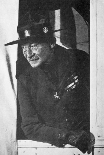man wearing a hat leaning out of a train window