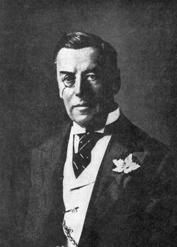 monacled man in 3-piece suit
