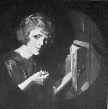girl holding jewels in her hand in front of open safe