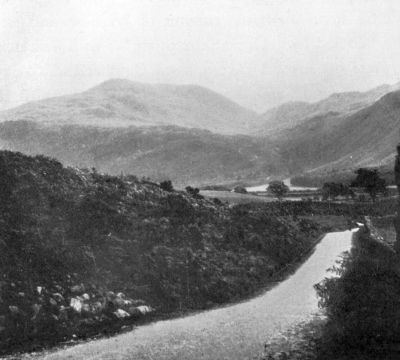 one lane road leading into the misty hills