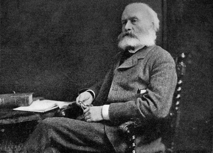 portrait of an older man sitting at a desk