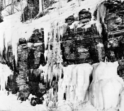 snow and icicles hanging off an outcrop of stone