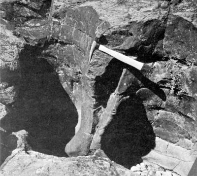 rock with holes and pickaxe showing scale