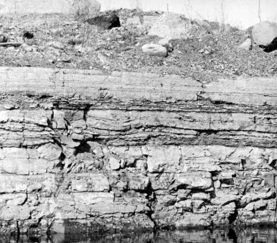 quarry wall with even limestone layers toped by glacial debris