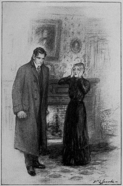 Man in long coat standing with clenched fists with small woman with hands clasping face