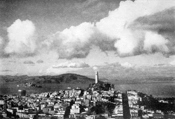 Coit Tower on Telegraph Hill with San Francisco Bay background and neighborhood streets in foreground