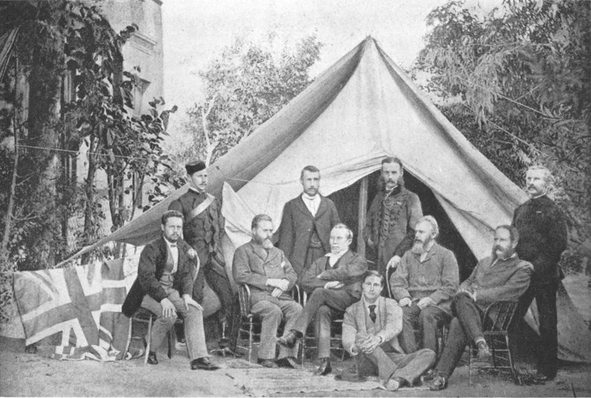 photo of men sitting before a tent