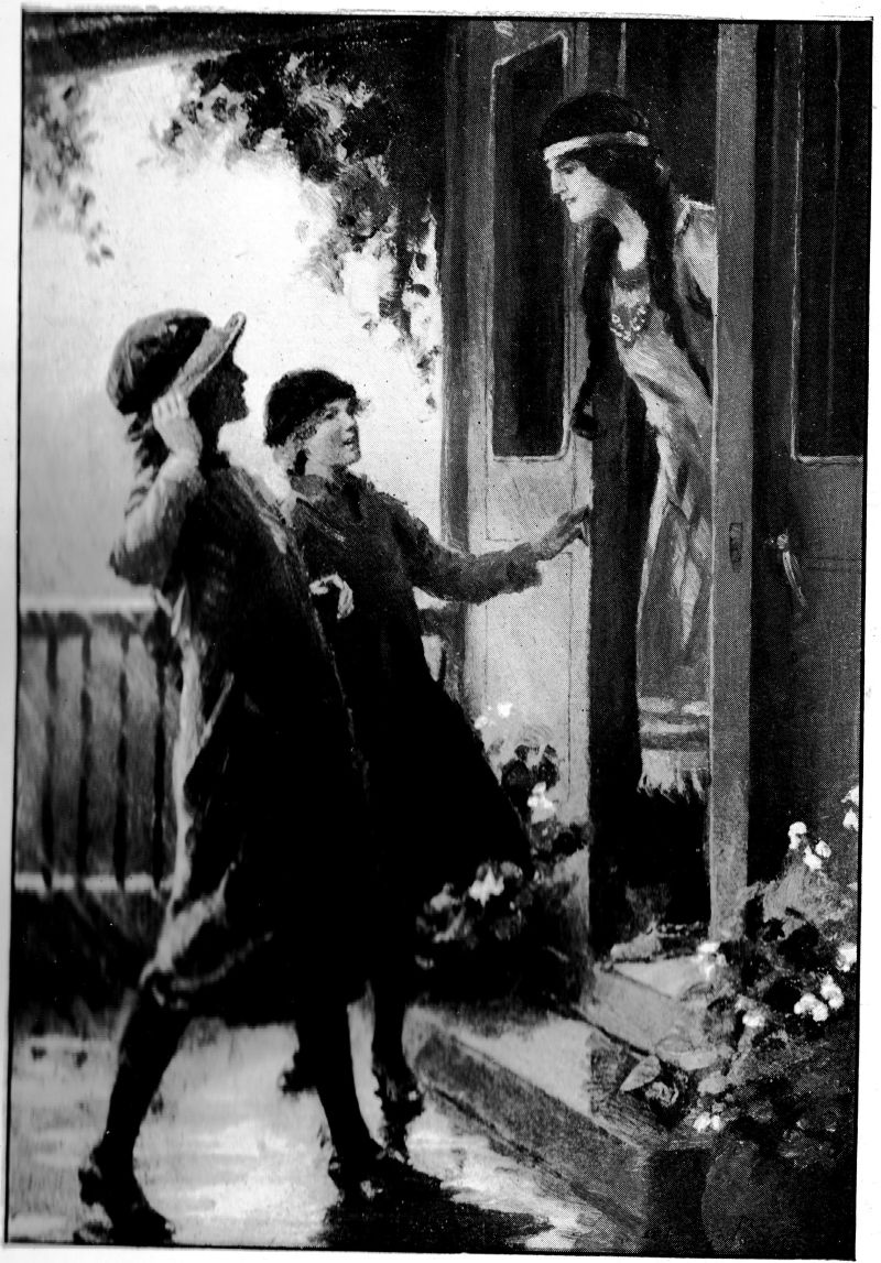 Two girls at the door of a third girl dressed in native clothes