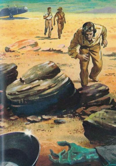 Biggles leaning over dead hand in foreground with plane and two men walking in desert towards Biggles