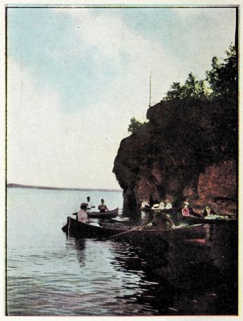 canoeists at base of prominent rock heading