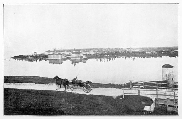 horse-drawn cart in foreground and bay and city in background