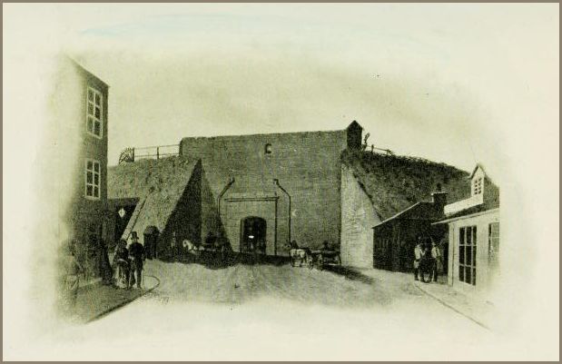Image of a fortified gateway flanked by sloping earthworks, with figures and horses gathered before its entrance and surrounding buildings.